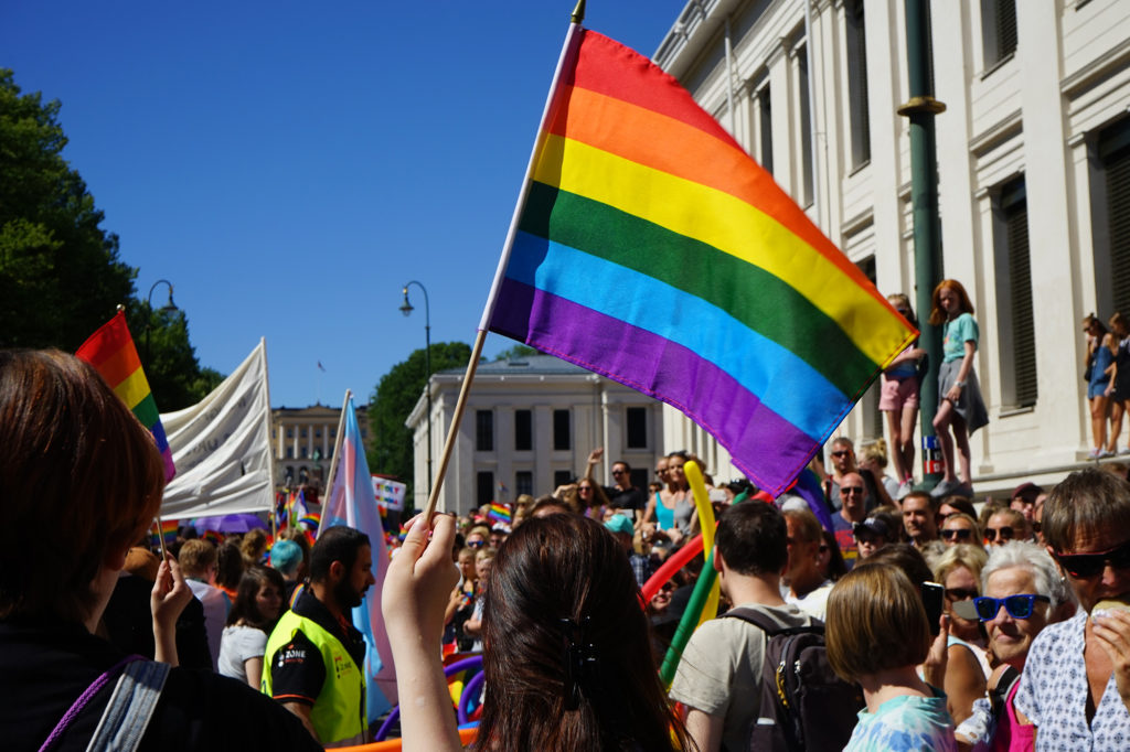 Folkemengde i Oslo Pride-parade, med særlig fokus på et regnbueflagg